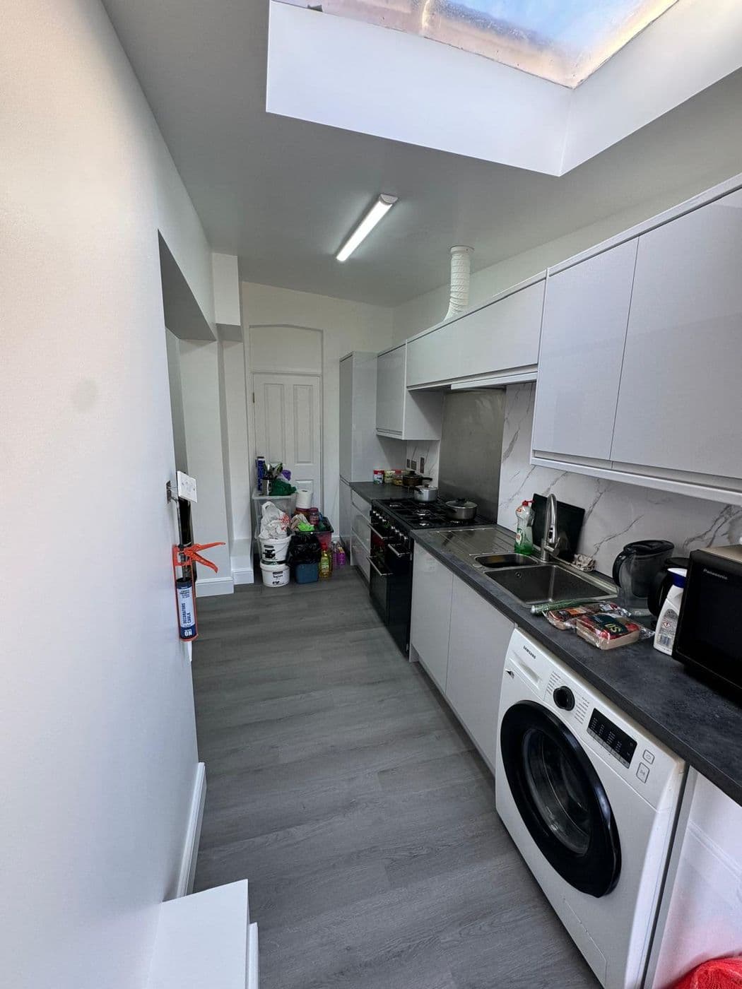 Modern fitted kitchen with a large island, pendant lighting and integrated appliances