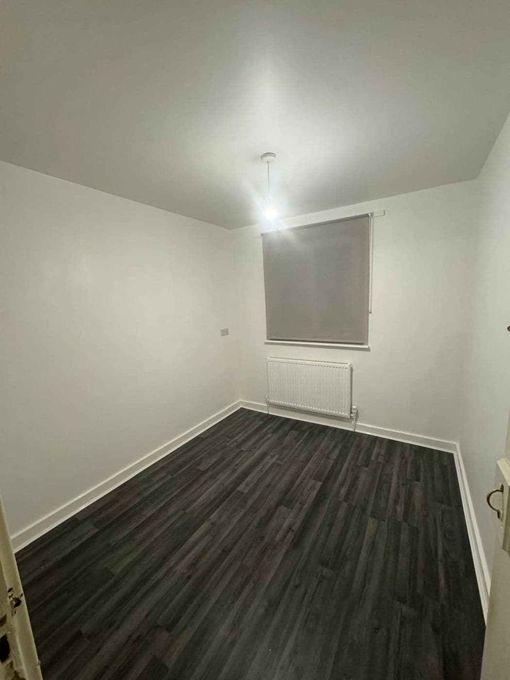 The same bedroom repainted in clean white with the woodwork cut in