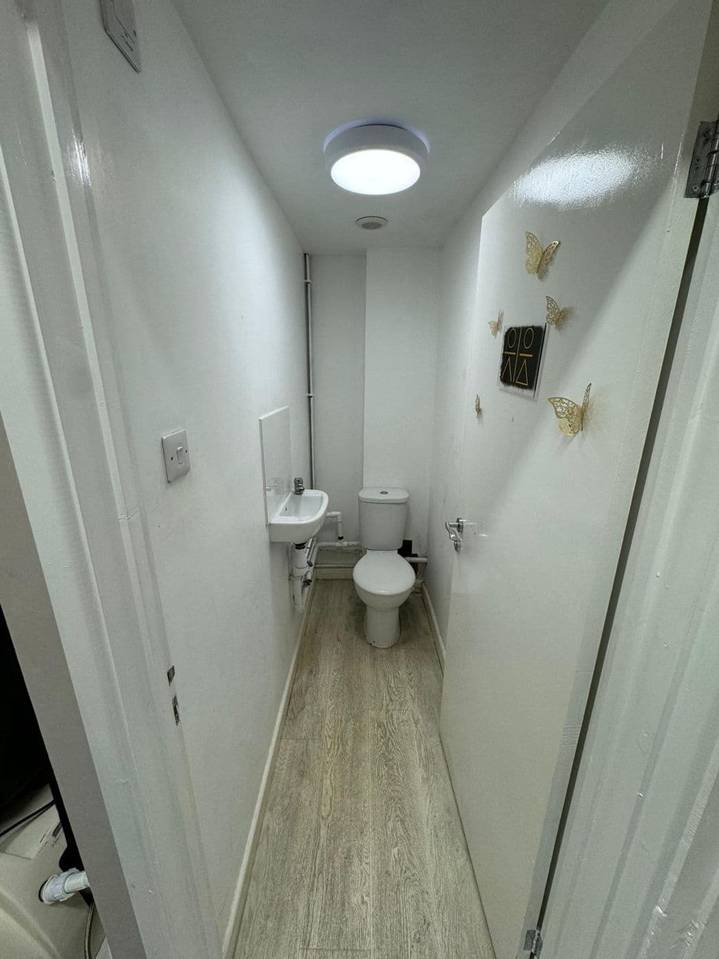 The cloakroom before work, painted plain white with a basin and WC
