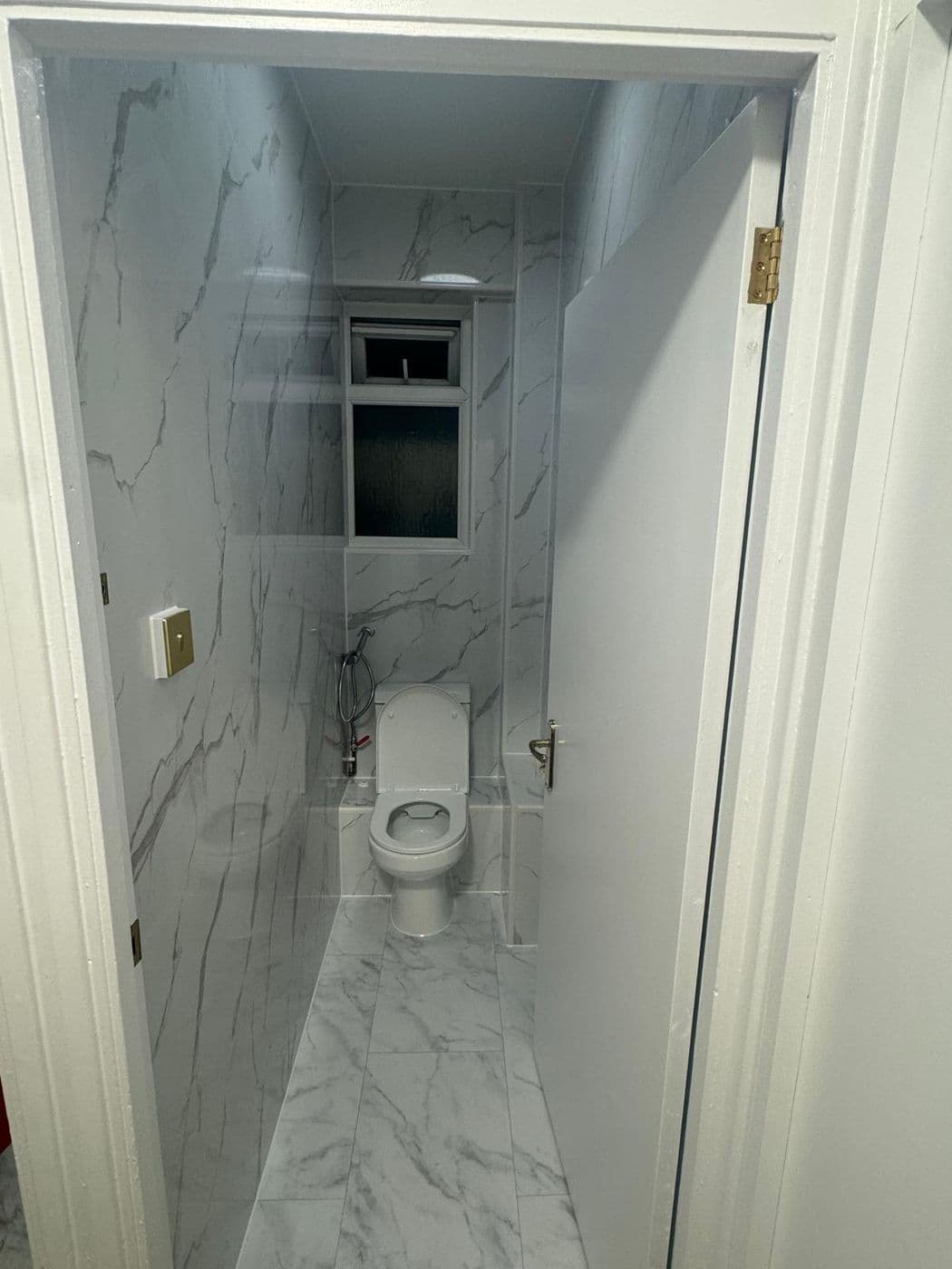 The same cloakroom tiled floor to ceiling in marble-effect porcelain