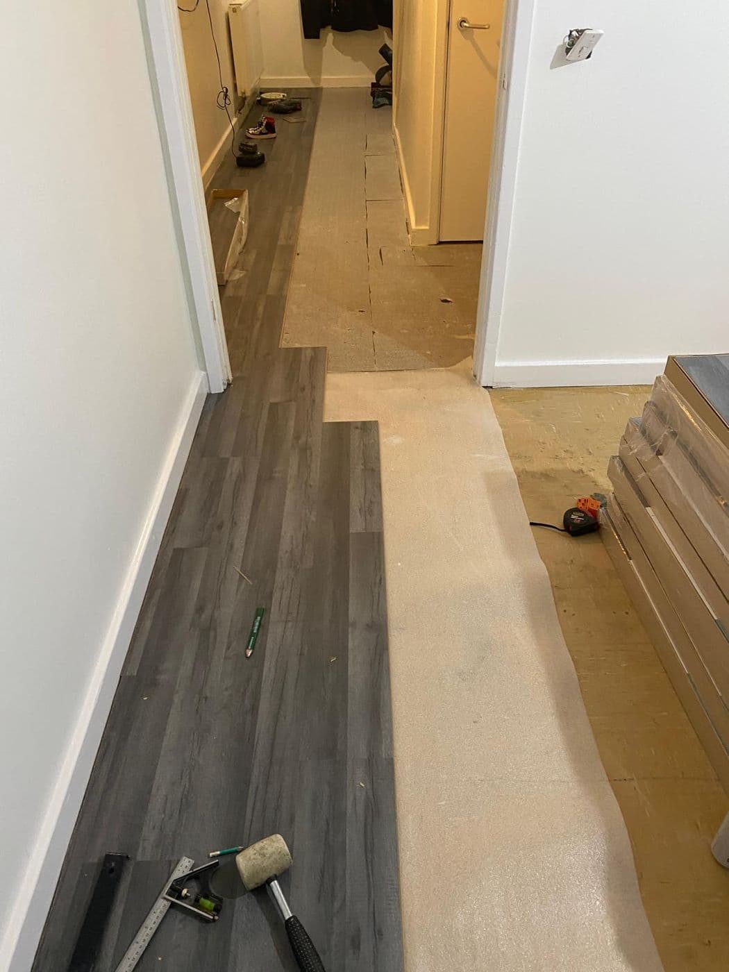 The hallway mid-fit, with LVT part-laid over the prepared subfloor