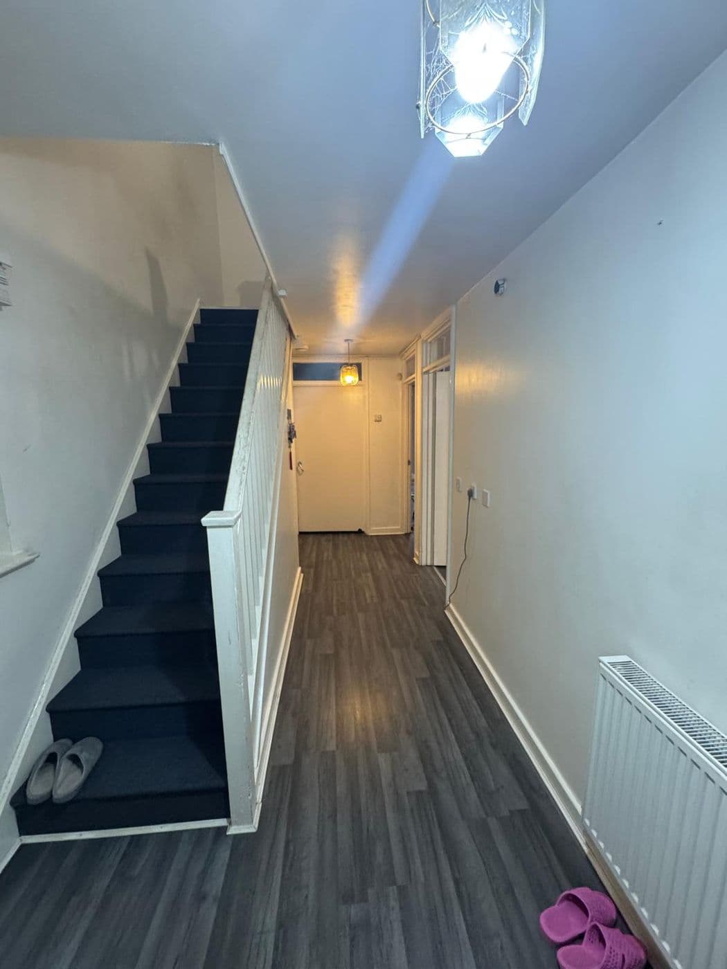 The hallway before work, with magnolia walls and a white painted staircase