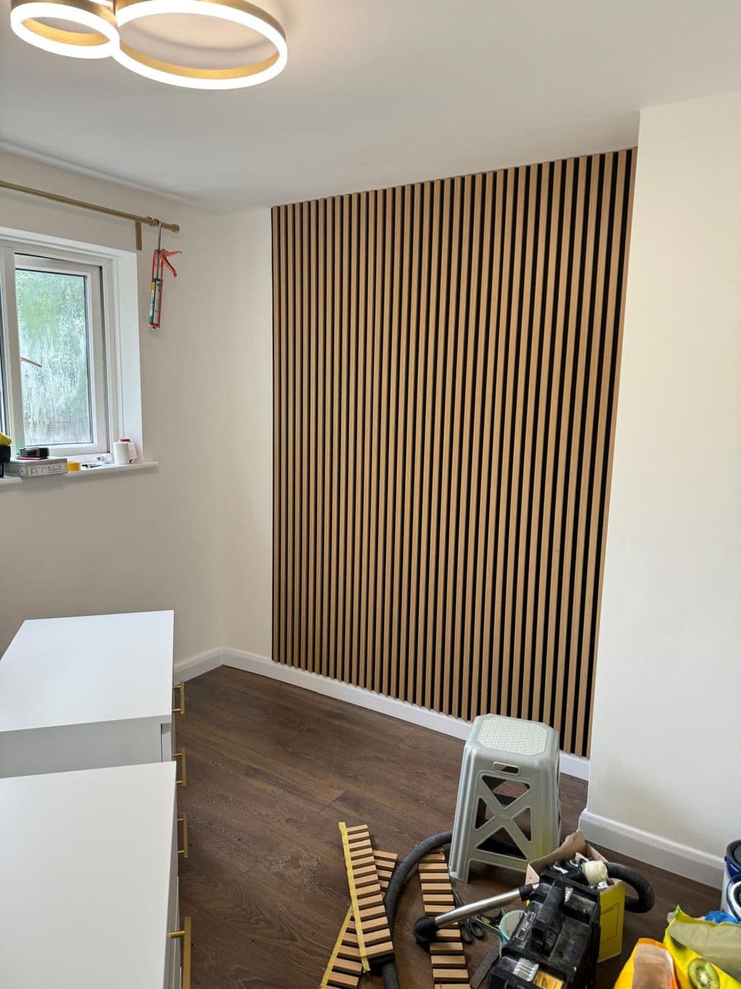 Full-height oak slat panelling fitted to a bedroom wall
