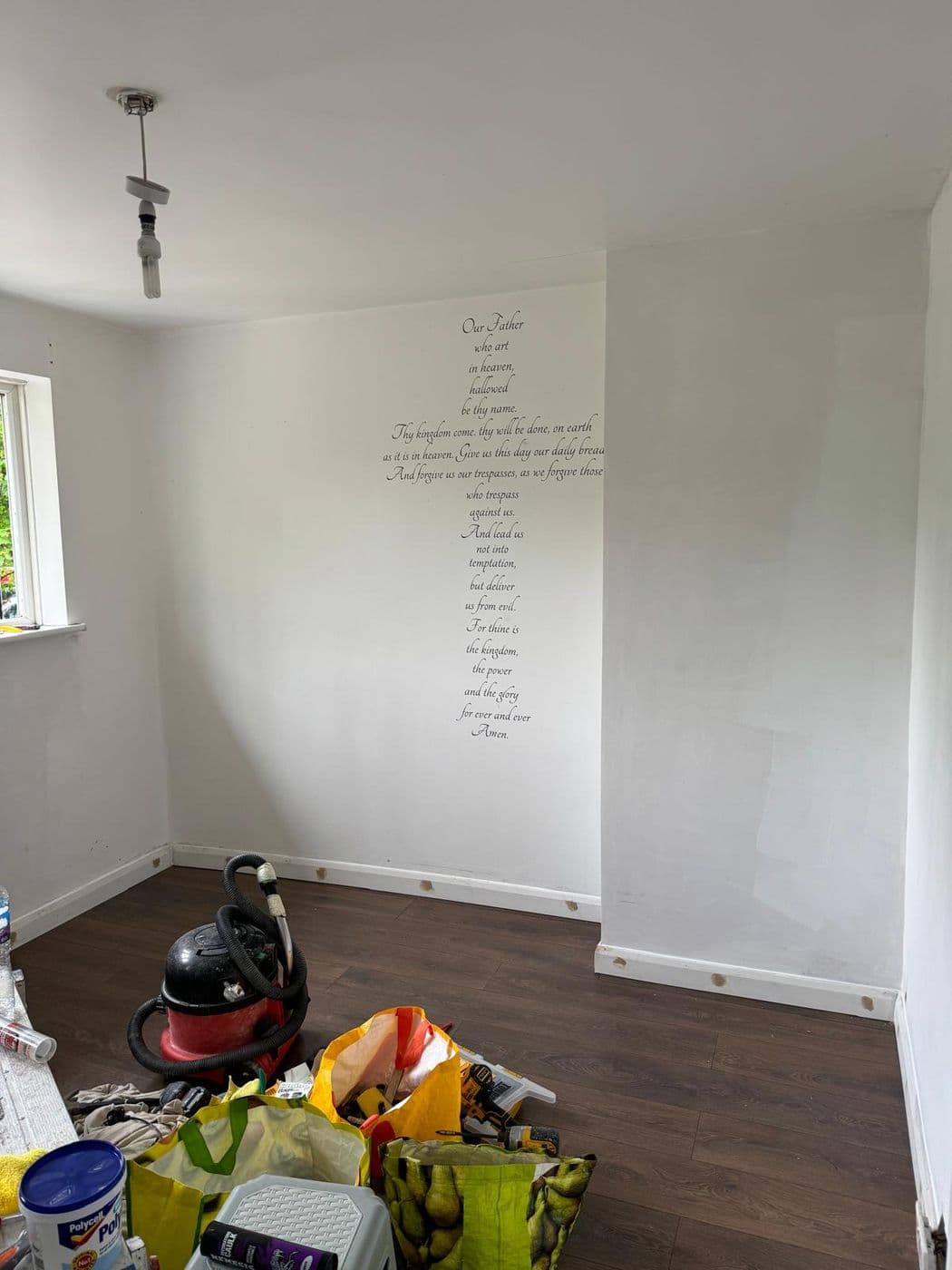 Decorative script lettering applied to a white wall in a freshly decorated room